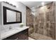 Bathroom featuring neutral colors, walk-in shower with glass, decorative mirror, granite counters and dark cabinets at 37221 N Holiday Ln, Carefree, AZ 85377