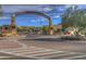 Elegant stone gateway at the entry to Carefree, Arizona with lush landscaping and clear blue skies at 37221 N Holiday Ln, Carefree, AZ 85377