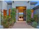 An inviting entryway adorned with blooming bushes, offering a glimpse into a stylishly furnished interior at 37221 N Holiday Ln, Carefree, AZ 85377