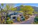 Gorgeous home with meticulously maintained landscaping, mature trees, and mountain views in background at 37221 N Holiday Ln, Carefree, AZ 85377