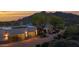Stunning home exterior featuring a three car garage, elegant desert landscaping, and mountain views at 37221 N Holiday Ln, Carefree, AZ 85377