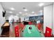 Spacious game room featuring a poker table, shuffleboard, pool table, and bar area for endless entertainment at 37221 N Holiday Ln, Carefree, AZ 85377