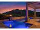 An inviting pool with a fire feature and a beautiful mountain backdrop at twilight at 37221 N Holiday Ln, Carefree, AZ 85377