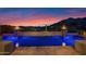 Beautiful backyard pool featuring fire bowls with colorful dusk mountain views at 37221 N Holiday Ln, Carefree, AZ 85377