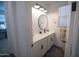Bright bathroom with a white vanity, round mirror, modern lighting, and fresh decor at 3911 S 78Th Ln, Phoenix, AZ 85043