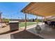 Backyard featuring a Blackstone grill, green turf, picnic table, string lights, and covered patio at 4117 W Whispering Wind Dr, Glendale, AZ 85310