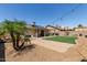Inviting backyard with covered patio, artificial lawn, pavers, and string lights; ideal for entertaining and relaxation at 4117 W Whispering Wind Dr, Glendale, AZ 85310