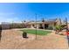 Expansive backyard with synthetic grass, patio, shed, string lights, and a fire pit at 4117 W Whispering Wind Dr, Glendale, AZ 85310