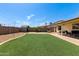 Large backyard with artificial turf, a storage shed, and a covered patio for entertaining at 4117 W Whispering Wind Dr, Glendale, AZ 85310