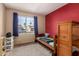 Cozy bedroom with a red accent wall and view of the neighborhood at 4117 W Whispering Wind Dr, Glendale, AZ 85310