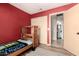 Red-themed bedroom with twin bed, sliding closet doors, and bathroom access at 4117 W Whispering Wind Dr, Glendale, AZ 85310