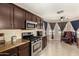Well-lit kitchen featuring granite countertops, stainless steel appliances, and dark wooden cabinetry at 4117 W Whispering Wind Dr, Glendale, AZ 85310