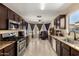 Spacious kitchen with stainless steel appliances, dark wood cabinets, and an adjacent living room space at 4117 W Whispering Wind Dr, Glendale, AZ 85310