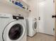 Functional laundry room with modern washer and dryer, plus shelving for supplies at 4117 W Whispering Wind Dr, Glendale, AZ 85310