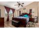 Comfortable main bedroom with a ceiling fan, wood-look floors, and plenty of natural light at 4117 W Whispering Wind Dr, Glendale, AZ 85310