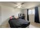 Bedroom features a ceiling fan, window with curtains, vanity and neutral-toned tile flooring at 4160 W Granada Rd, Phoenix, AZ 85009