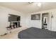 This bedroom features a large-screen television and neutral-colored tile flooring at 4160 W Granada Rd, Phoenix, AZ 85009