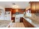 Well-lit kitchen with granite counters, wood cabinets, and modern appliances at 4160 W Granada Rd, Phoenix, AZ 85009