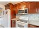 Features of this kitchen include wooden cabinets, a microwave, stove, and a white refrigerator at 4160 W Granada Rd, Phoenix, AZ 85009