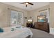Comfortable bedroom featuring a ceiling fan, large window, and a dresser with a mirror at 4293 E Sourwood Dr, Gilbert, AZ 85298