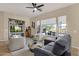 Bright living room featuring large windows with blinds, a ceiling fan, and stylish furniture at 4293 E Sourwood Dr, Gilbert, AZ 85298
