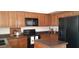 Well-equipped kitchen with black appliances, warm wood cabinetry, and dark countertops for a modern look at 475 S Seawynds Blvd, Gilbert, AZ 85233