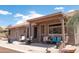 Covered back porch with desert views, equipped with patio seating, a grill, and convenient access to the backyard at 4970 S Desert Willow Dr, Gold Canyon, AZ 85118