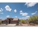 Beautiful single-story desert home with a tile roof, complemented by lush desert landscaping and a picturesque skyline at 4970 S Desert Willow Dr, Gold Canyon, AZ 85118