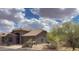 Exterior of a beautiful desert home with a tiled roof, mature trees and landscaping at 4970 S Desert Willow Dr, Gold Canyon, AZ 85118