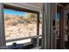Inviting view from inside towards an outdoor patio and rocky desert landscape, framed by elegant curtains at 4970 S Desert Willow Dr, Gold Canyon, AZ 85118