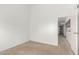 This vacant bedroom has neutral carpeting and access to the kitchen at 520 N Stapley Dr # 253, Mesa, AZ 85203