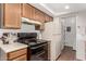 Functional kitchen with wood cabinetry, and black appliances, complemented by in-unit laundry at 520 N Stapley Dr # 253, Mesa, AZ 85203