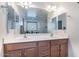 Well-lit bathroom with double sinks, wood cabinets, and large mirrors over a spacious counter at 5239 W Leodra Ln, Laveen, AZ 85339