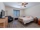 Comfortable bedroom with wood-look floors, a ceiling fan and a chair for relaxing and watching TV at 5239 W Leodra Ln, Laveen, AZ 85339