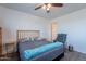 Bedroom showcasing a neatly made bed with a wooden headboard, complemented by a cozy chair and neutral wall color at 5239 W Leodra Ln, Laveen, AZ 85339