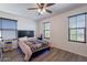 This cozy bedroom features a ceiling fan, gray wood-look floors and plenty of natural light at 5239 W Leodra Ln, Laveen, AZ 85339
