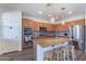 Modern kitchen features a center island with granite countertops, stainless appliances, and stylish lighting at 5239 W Leodra Ln, Laveen, AZ 85339