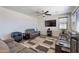 Spacious living room featuring hardwood floors, ceiling fan, large TV, and comfortable couches at 5239 W Leodra Ln, Laveen, AZ 85339
