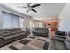 Open concept living room featuring hardwood floors, ceiling fan, large TV, and comfortable couches at 5239 W Leodra Ln, Laveen, AZ 85339
