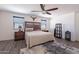 Comfortable main bedroom features a rustic wooden bed frame, ceiling fan and gray wood-look floors at 5239 W Leodra Ln, Laveen, AZ 85339