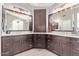 Elegant bathroom with double sinks, dark cabinets, and stunning light fixtures at 6026 E Sonoran Trl, Scottsdale, AZ 85266