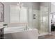 Bright bathroom featuring a soaking tub with chandelier and glass-enclosed shower at 6026 E Sonoran Trl, Scottsdale, AZ 85266