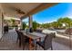 Spacious covered patio features outdoor dining, lounge seating, and a view of the beautiful pool and backyard at 6026 E Sonoran Trl, Scottsdale, AZ 85266