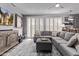 Comfortable living room with a large sectional, ottoman, stylish shutters, and entertainment center at 6026 E Sonoran Trl, Scottsdale, AZ 85266