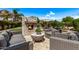 Outdoor living space with built-in fireplace, cozy seating, putting green, and lush landscaping for relaxation at 6026 E Sonoran Trl, Scottsdale, AZ 85266