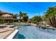 Inviting pool area with rock features, lounge chairs, lush landscaping and a putting green in backyard at 6026 E Sonoran Trl, Scottsdale, AZ 85266