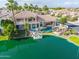 Aerial view of a luxury lakeside home featuring a pool, lounge area, boat dock, and water access at 633 W Aster Ct, Chandler, AZ 85248