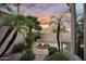 The backyard features a stone fire pit, seating, palm trees, and beautiful desert landscaping at 633 W Aster Ct, Chandler, AZ 85248
