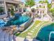Custom backyard with a pool featuring unique waterfall, seating, access to waterfront, and outdoor kitchen at 633 W Aster Ct, Chandler, AZ 85248