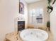 Bright bathroom boasts a jacuzzi tub next to a cozy fireplace and shuttered windows at 633 W Aster Ct, Chandler, AZ 85248